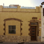 "Façana d´una casa d´estil rústic amb porta de fusta i parets de pedra."